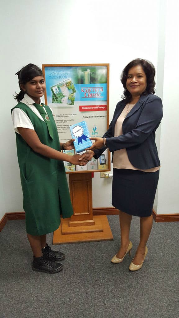 Ms Kavita Rohan,of Canal No 2 receives her prize from GBTI's Vreed-En-Hoop Branch Manager Ms Nandanee Persaud