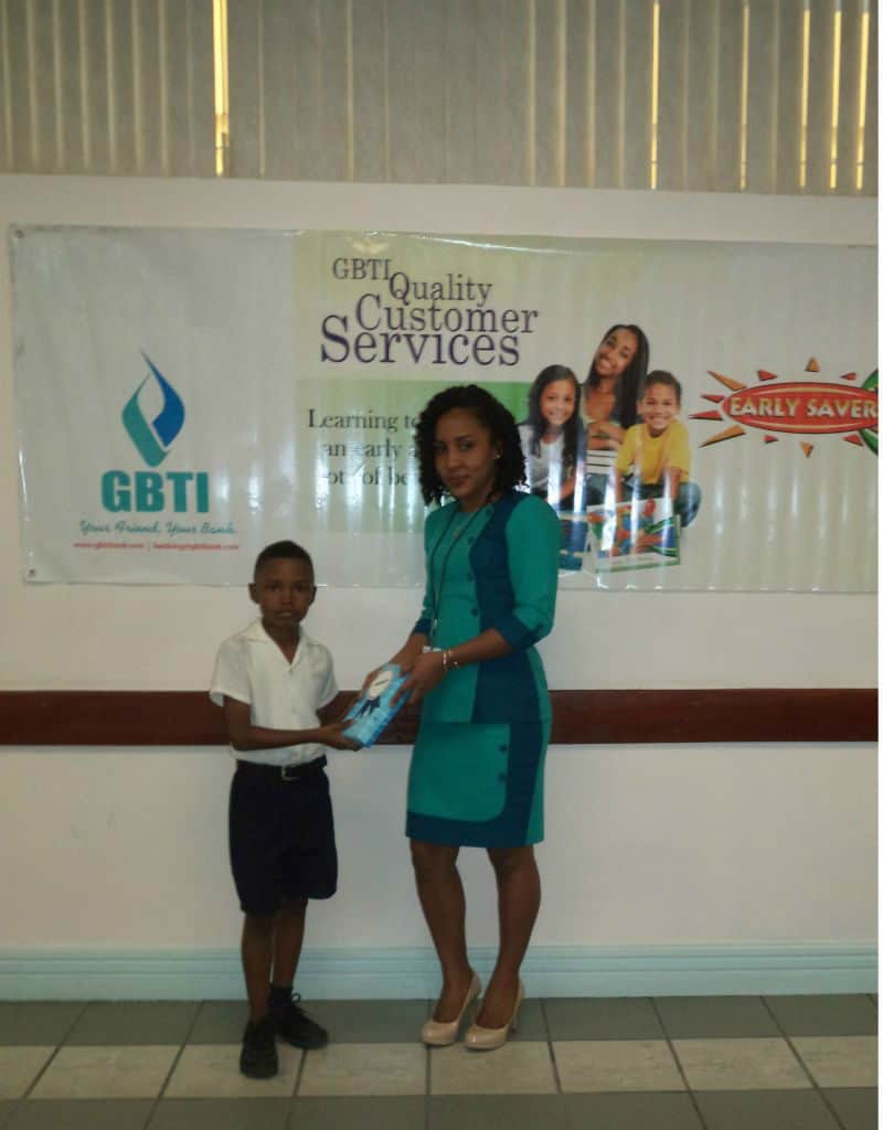 Jaden Persaud receives his prize from GBTI Regent Street Staff Ms Noelle Jeffrey